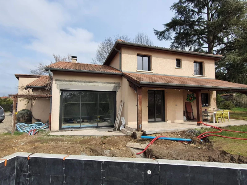 Façade de maison en chantier avec une nouvelle grande baie vitrée