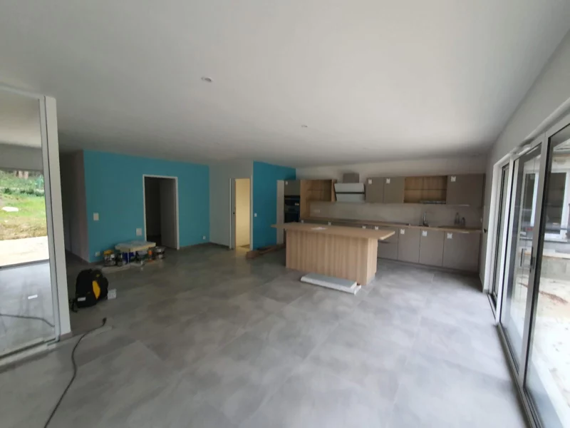 Grande pièce de vie avec îlot de cuisine en fin de chantier